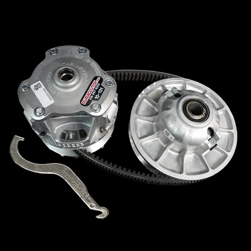 Snowmobile clutch and belt kit with a wrench, against a black background.